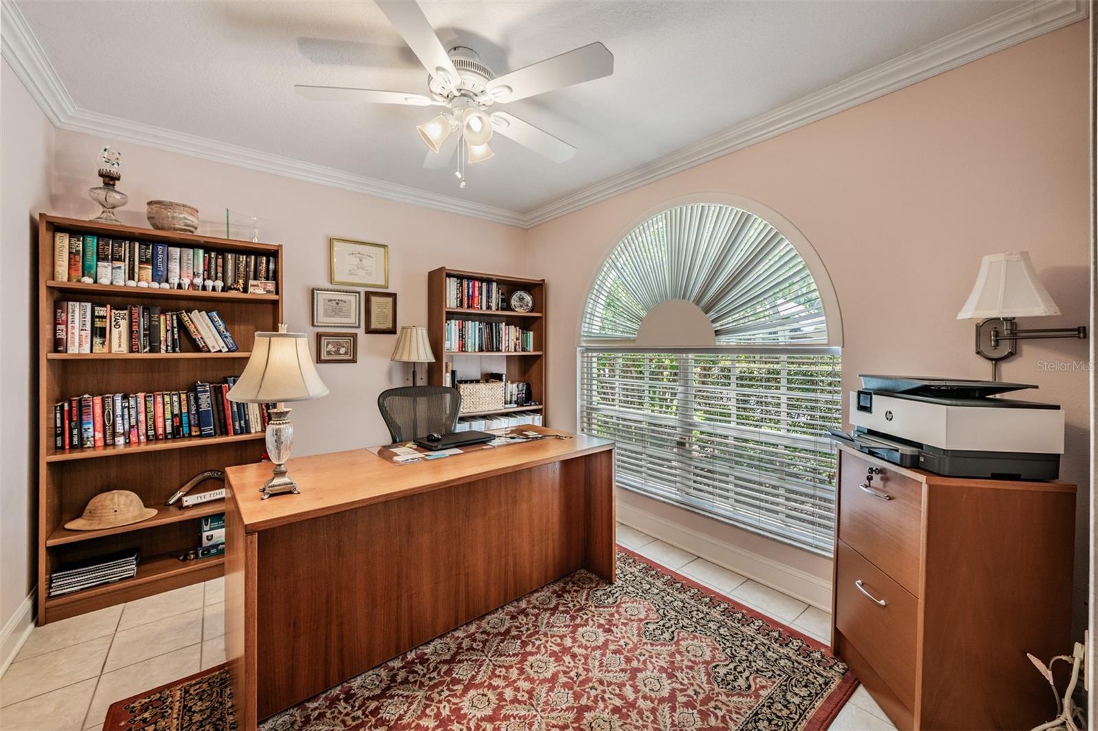 Front office with crown molding, ceiling fan with lights, tile floors