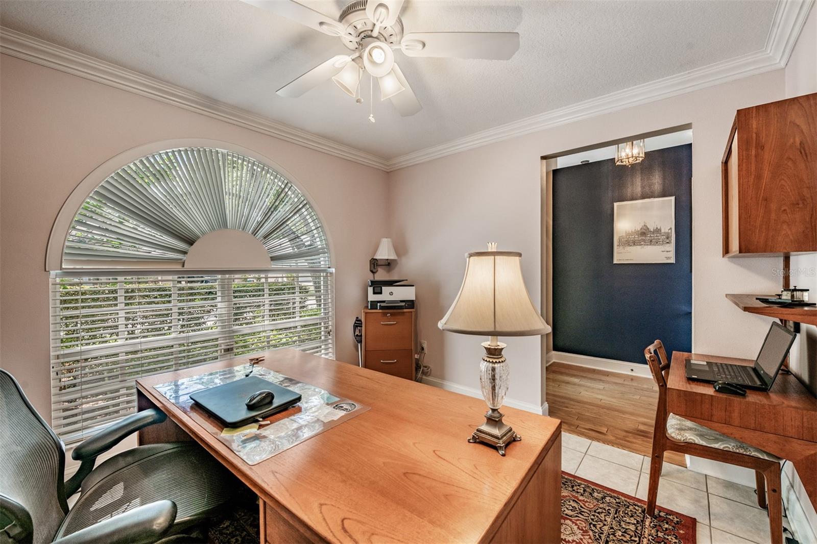 Front office just off the entry way, Ceiling fan with lights, tile flooring and crown molding.