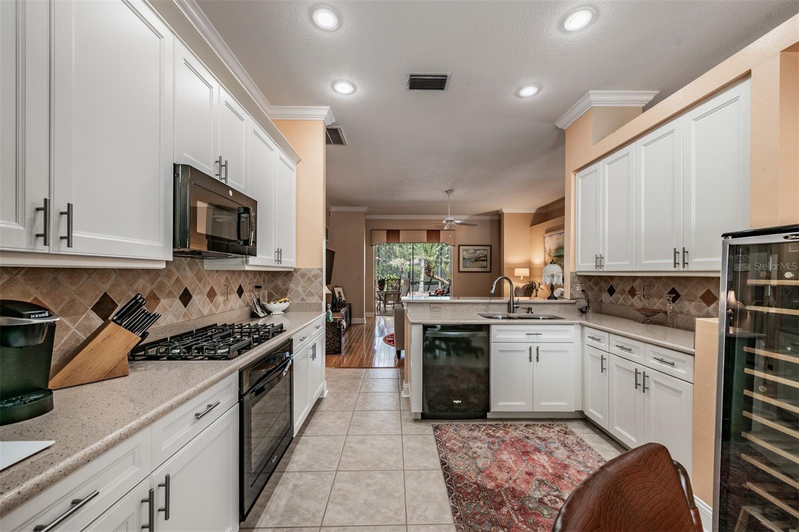 Open Kitchen to the Family Room, Stone Countertops, Stainless Steel Appliances, Gas Range, Tile Flooring, Inset Lighting and lots of sunlight.