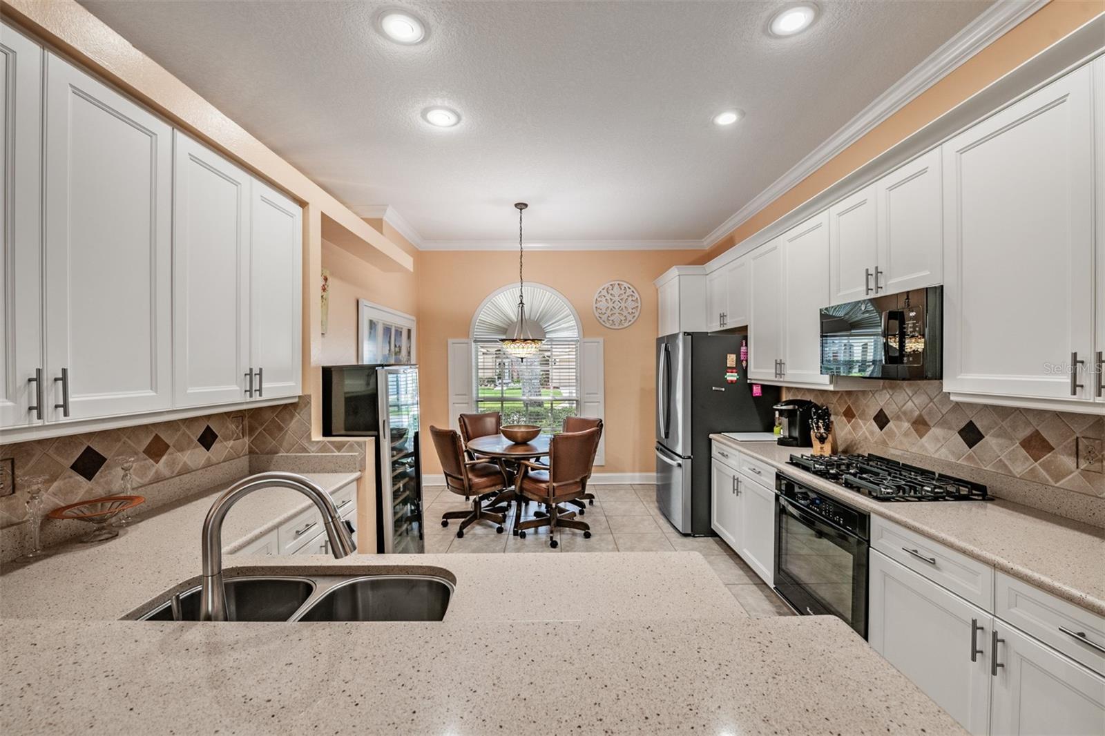 Open Kitchen to the Family Room, Stone Countertops, Stainless Steel Appliances, Gas Range, Tile Flooring, Inset Lighting and lots of sunlight.