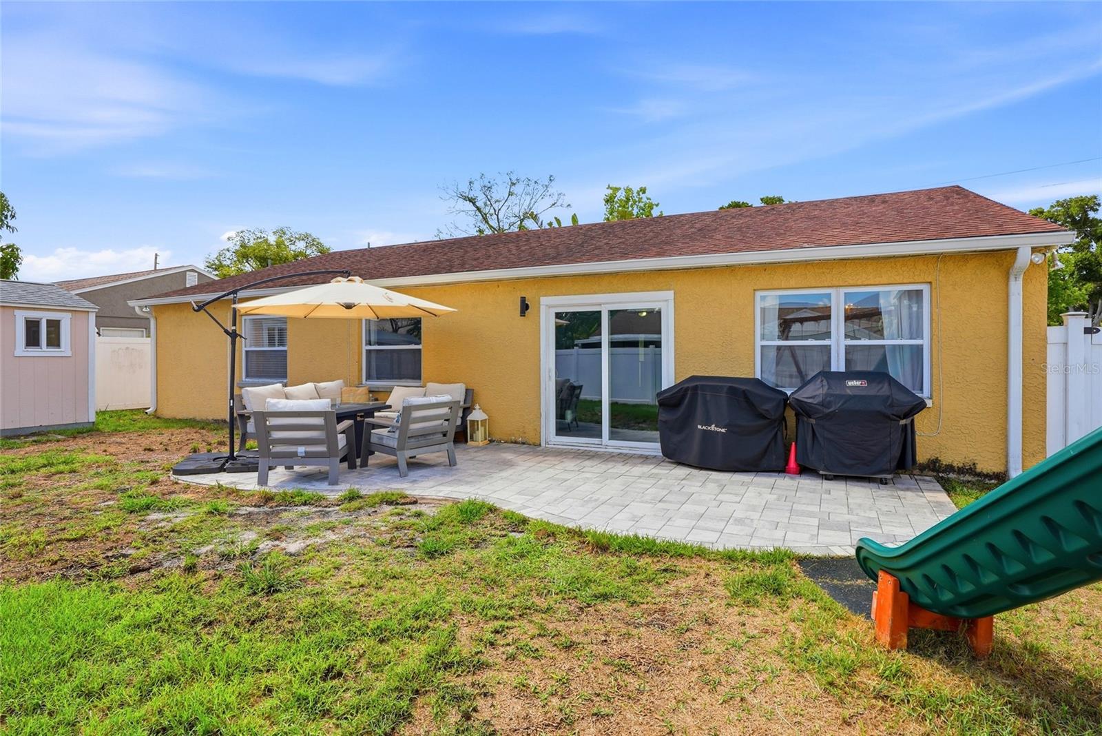 Your fully fenced backyard complete with paver patio, shed and playground!