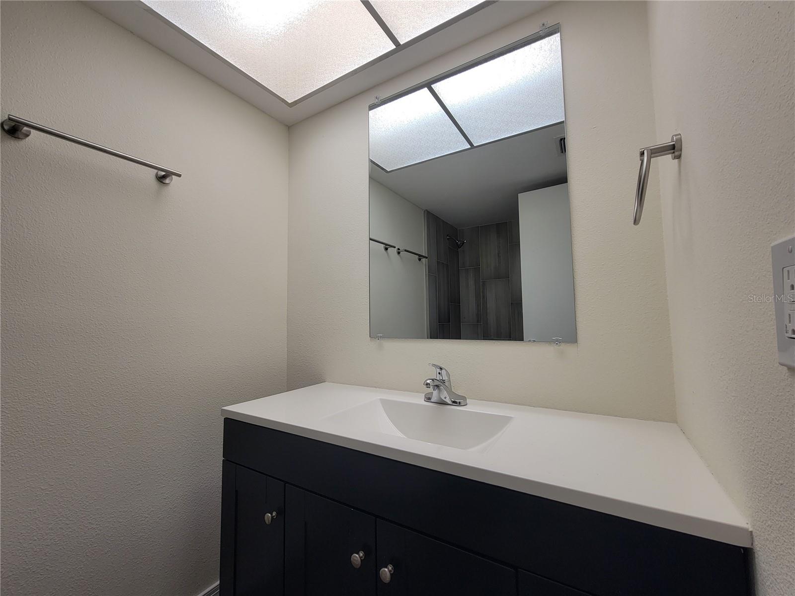 Renovated en-suite bathroom with new vanity, fixtures & hardware.