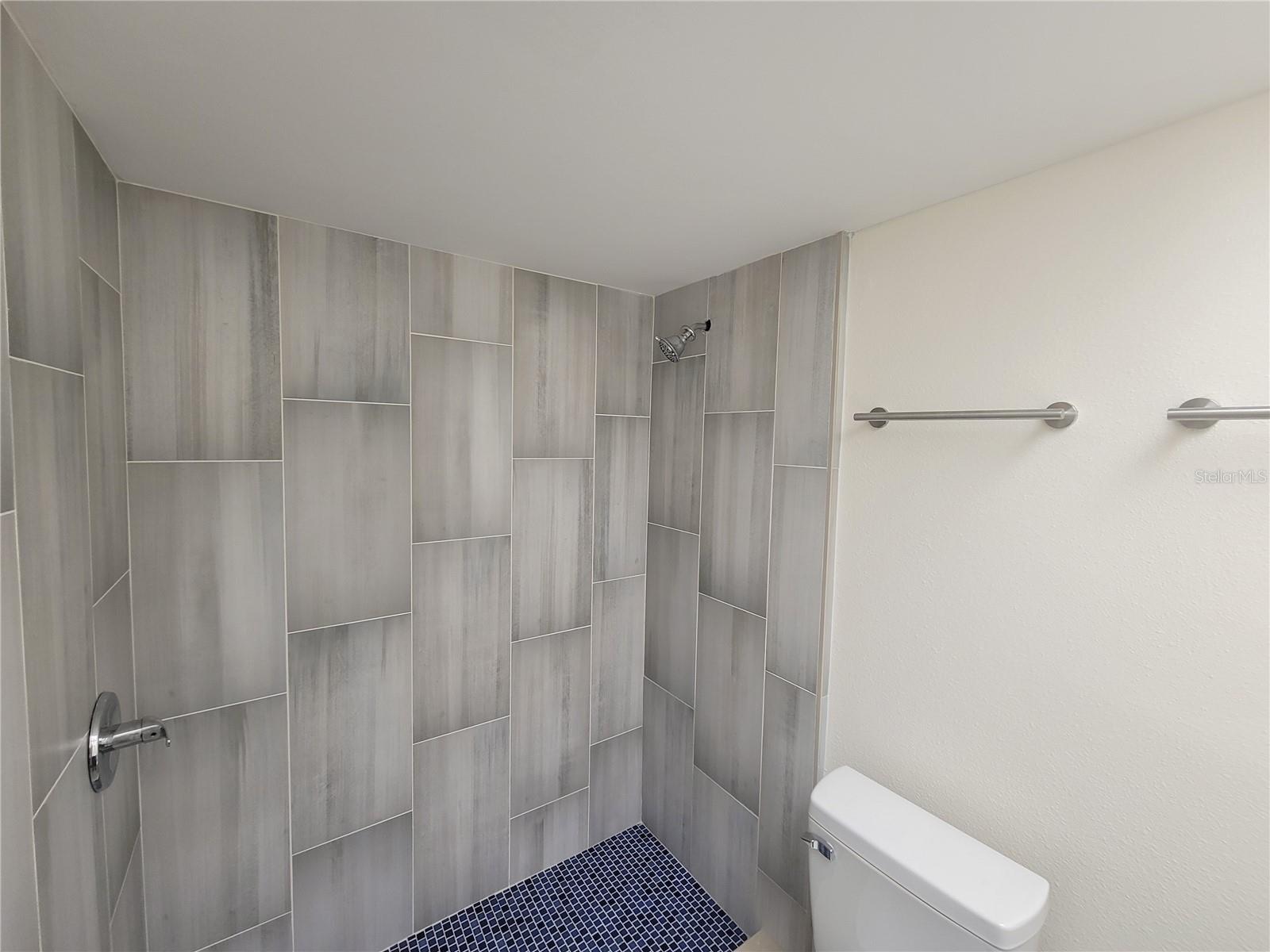 Fully-tiled walk-in shower in primary bahroom