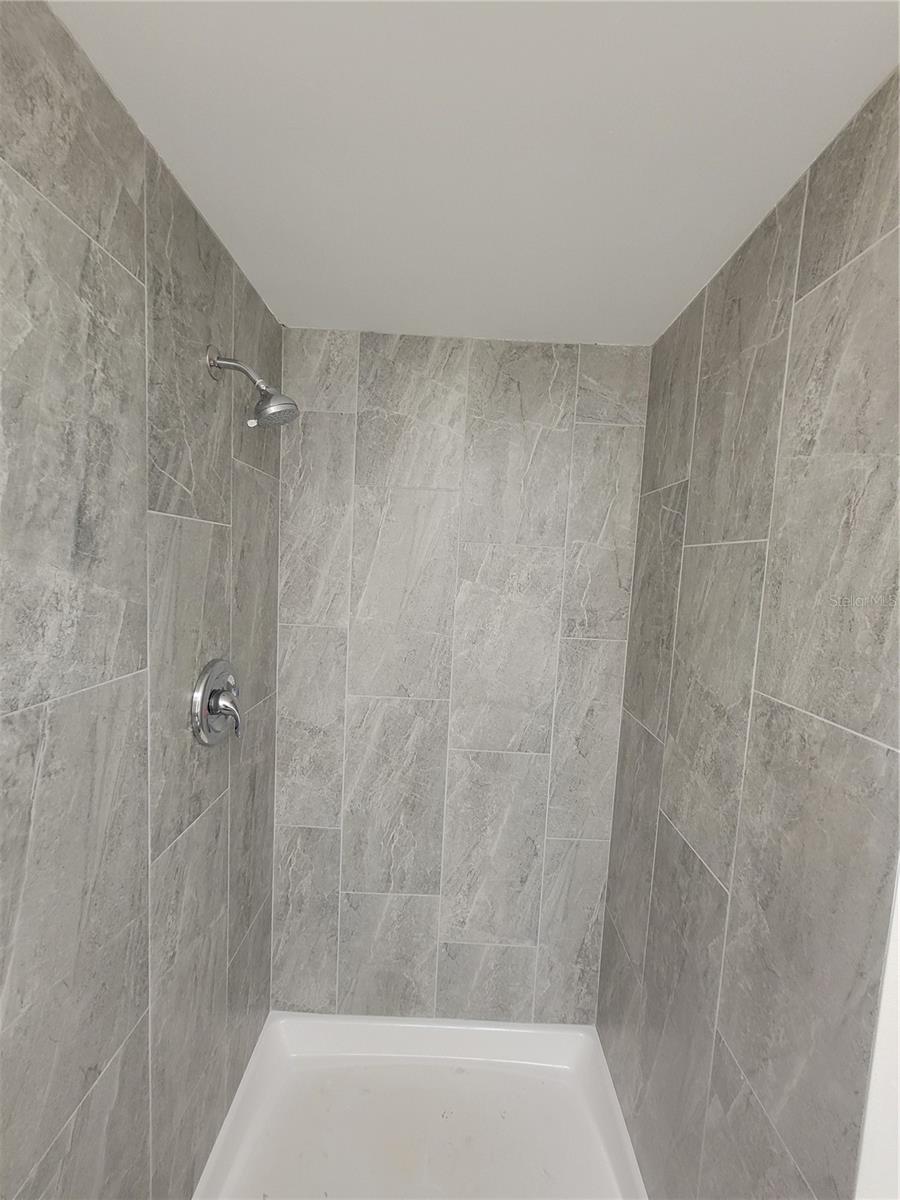 Guest bathroom features tiled shower.
