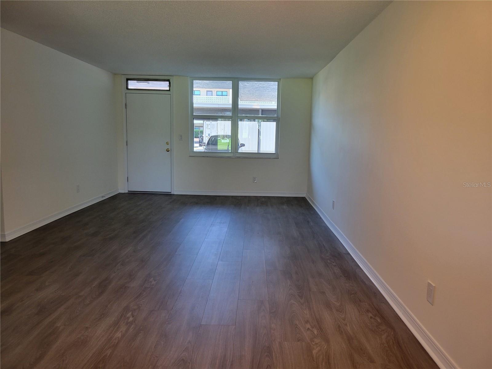 View from breakfast bar overlooking dining and living room with entrance in rear.