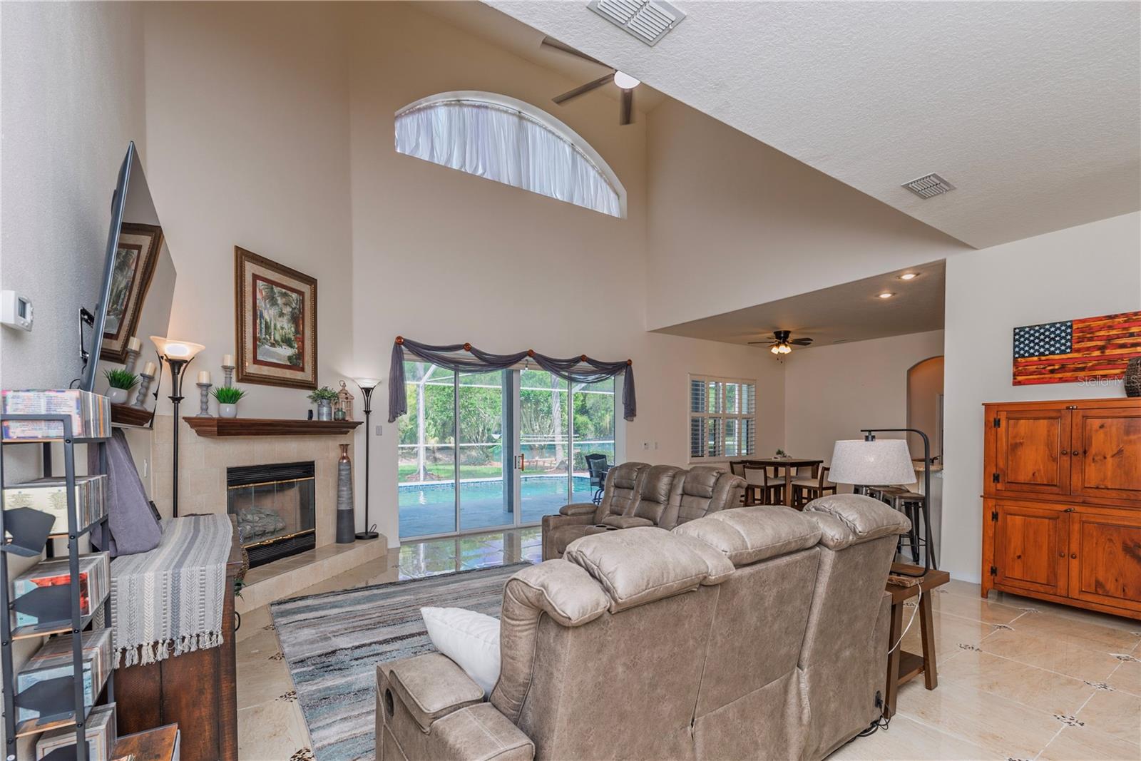 Spacious living room featuring high ceilings and seamless flow to the pool area.