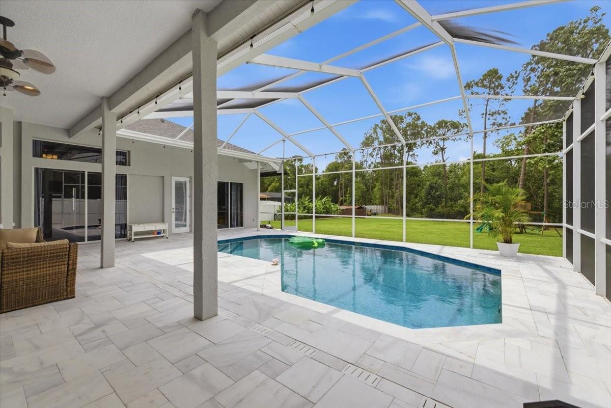 saltwater pool with sand blasted marble pavers and marble drains, lanai enclosure.