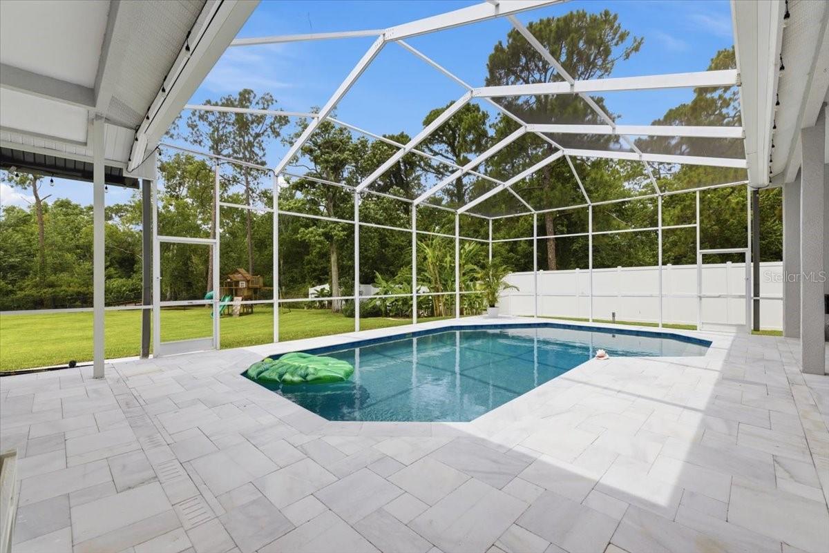 saltwater pool with sand blasted marble pavers and marble drains, lanai enclosure.