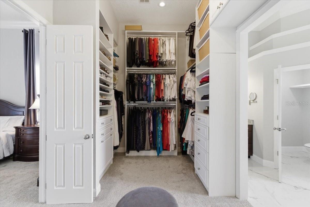 Primary Closet, oversized with 3 tiers of sleving and custom storage and hidden storage not photographed.
