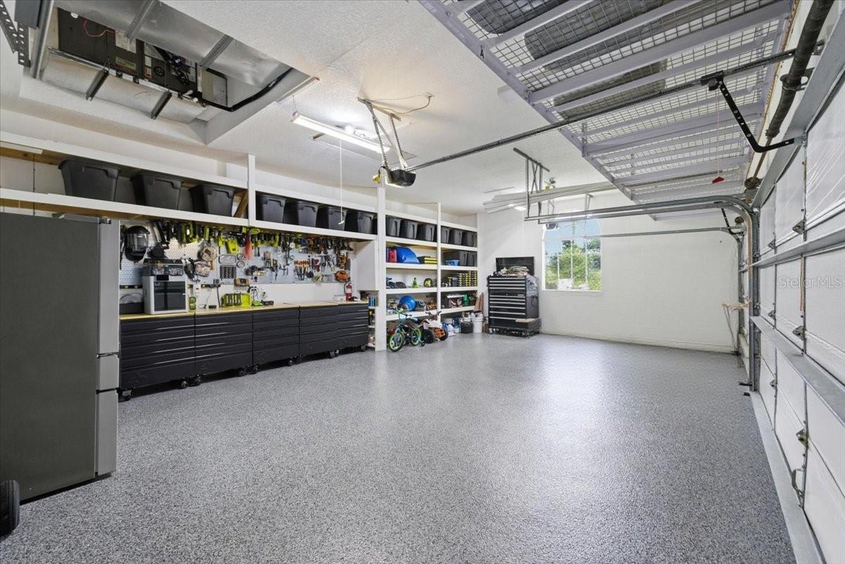 garage with custom shelving and fresh paint and epoxy floor covering