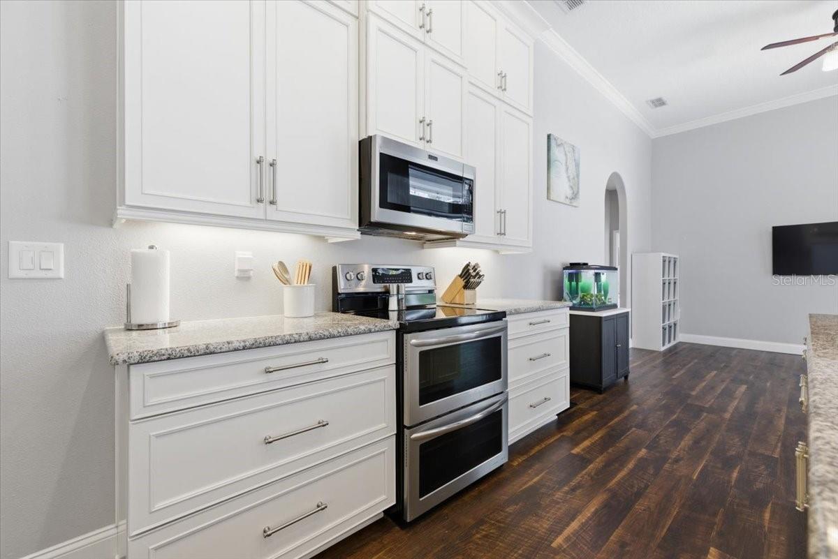 Kitchen with custom cabinents, crown molding, LVP, tons of storage, and custom pantry organization built in system.