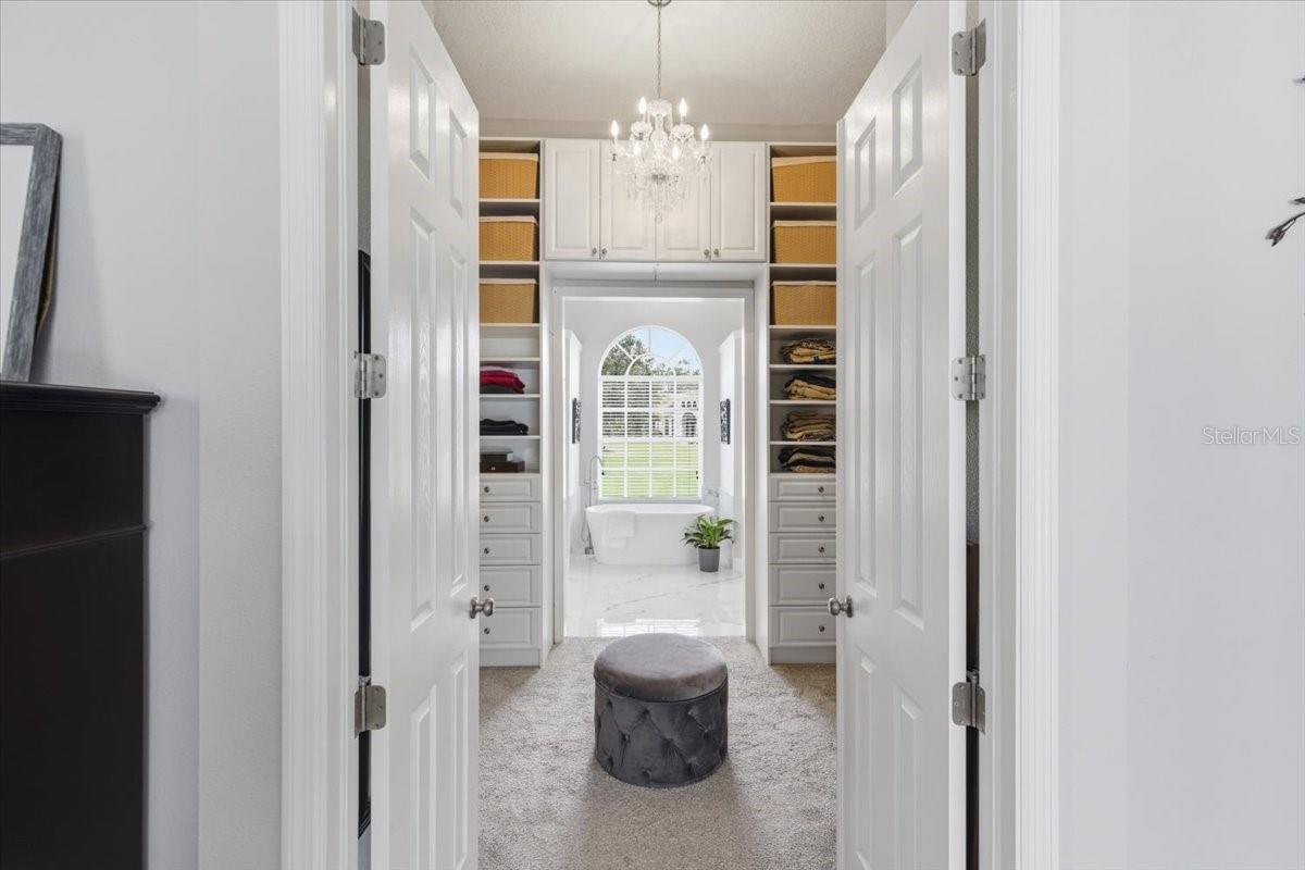 Primary Closet, oversized with 3 tiers of sleving and custom storage and hidden storage not photographed.