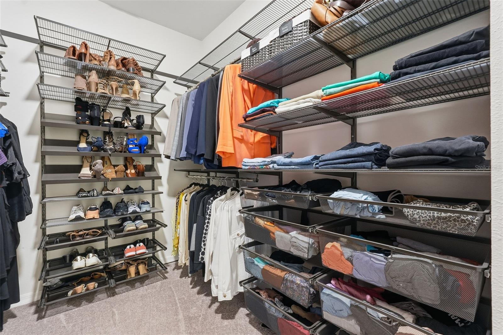 Primary bedroom's walk in closet with custom organizers
