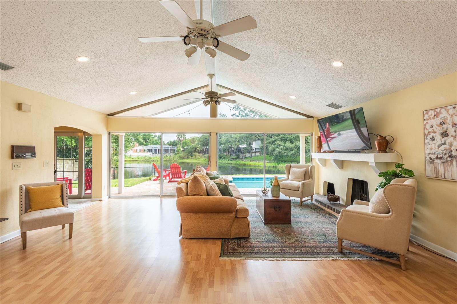 Large windows and sliders showcase the stunning view of the pool and lake.