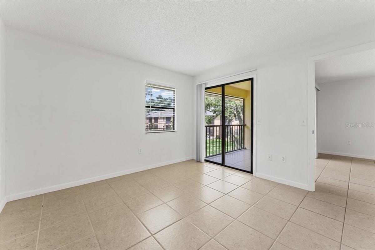 Primary bedroom with slider to screened porch balcony