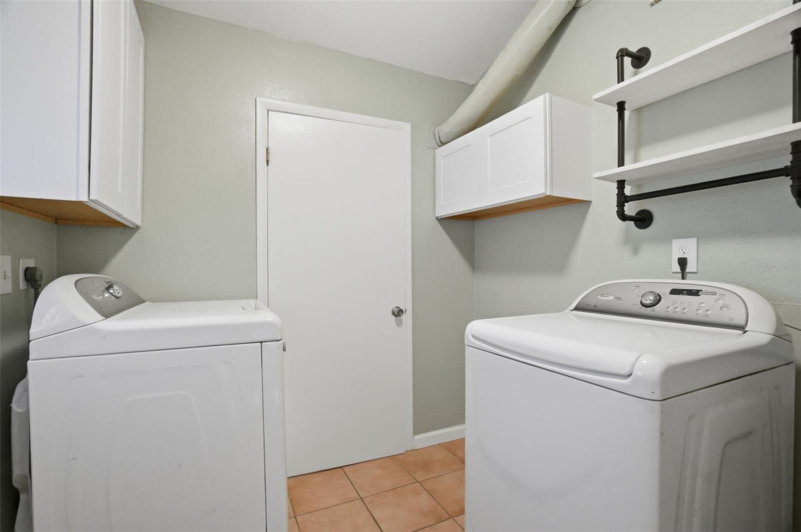Laundry room which connects the primary bath and the kitchen. Also has a door to the side yard