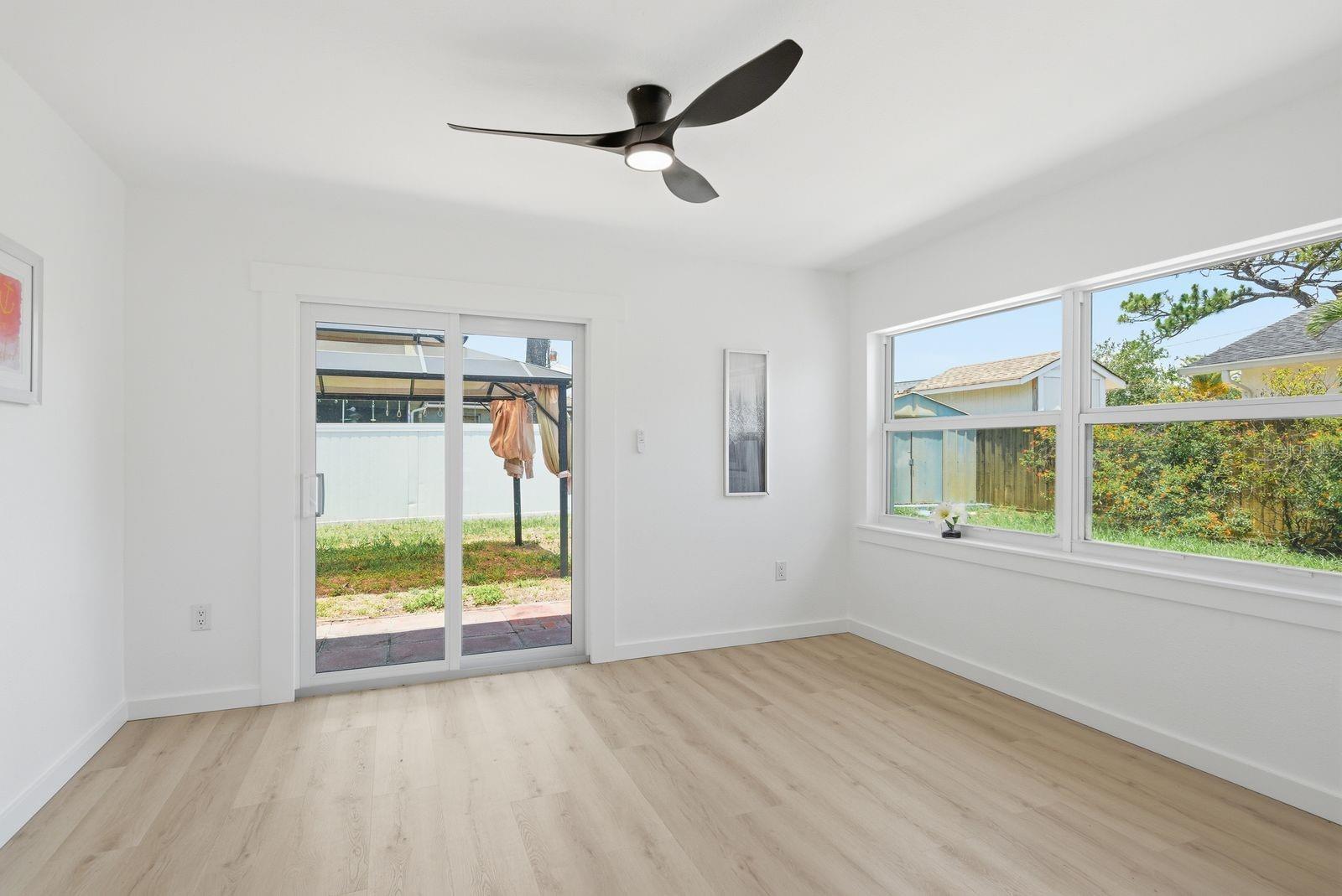 There is also a spacious dining area surrounded by large windows and sliding glass doors leading to the backyard, creating seamless indoor-outdoor living.
