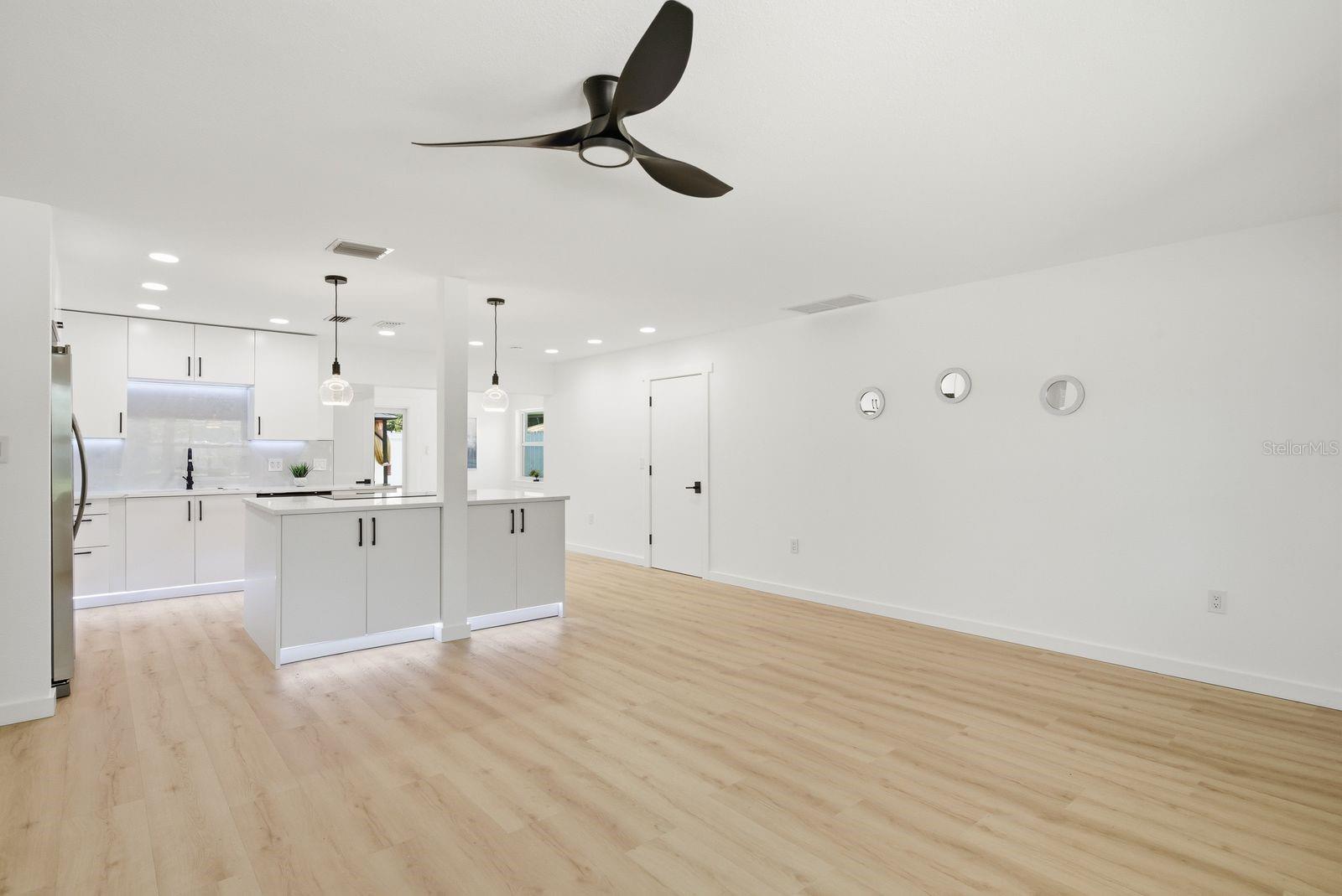 The fully renovated kitchen offers a large island, under-cabinet lighting, and pendant lights.