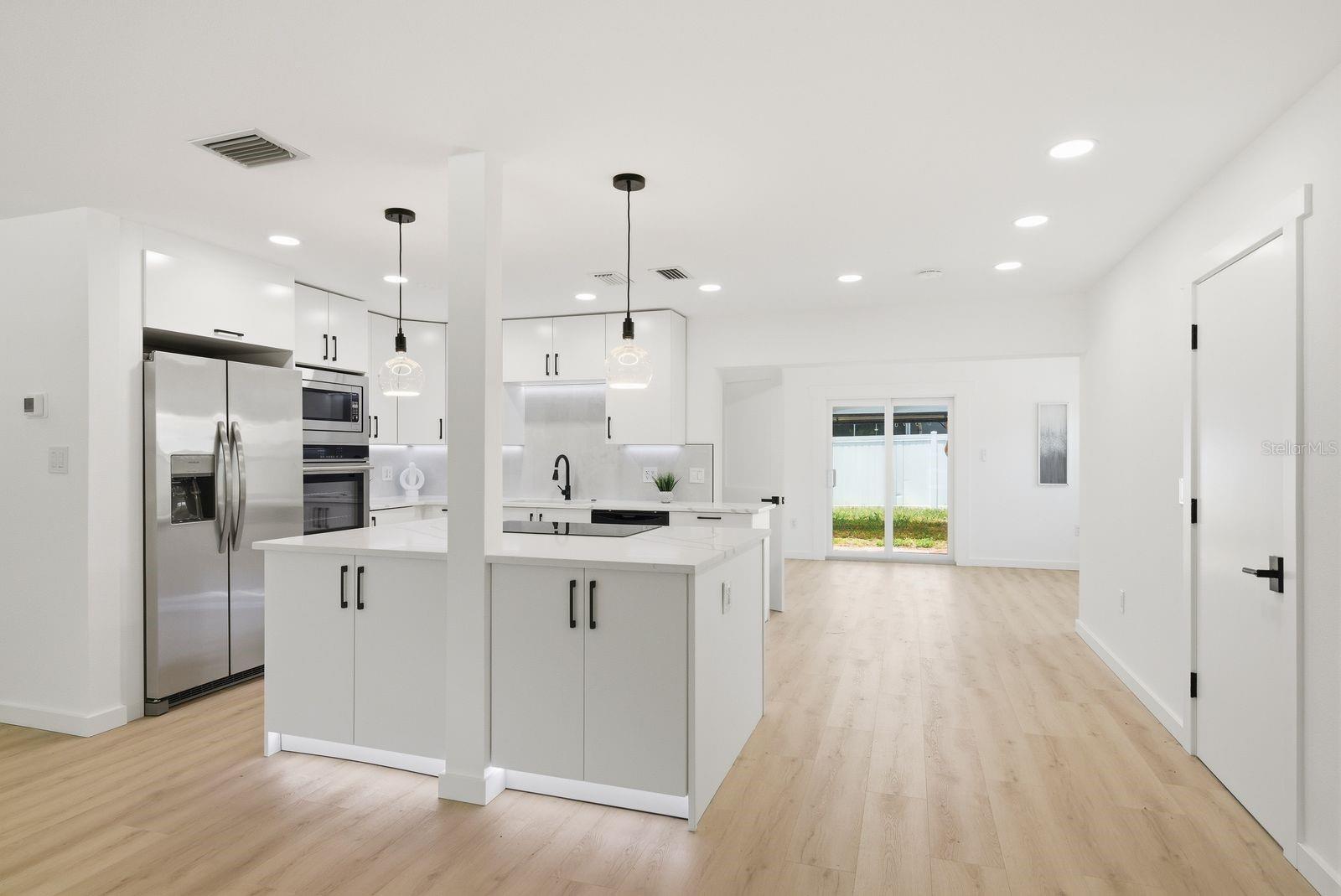 The kitchen features stainless steel appliances, and sleek modern finishes perfect for entertaining.