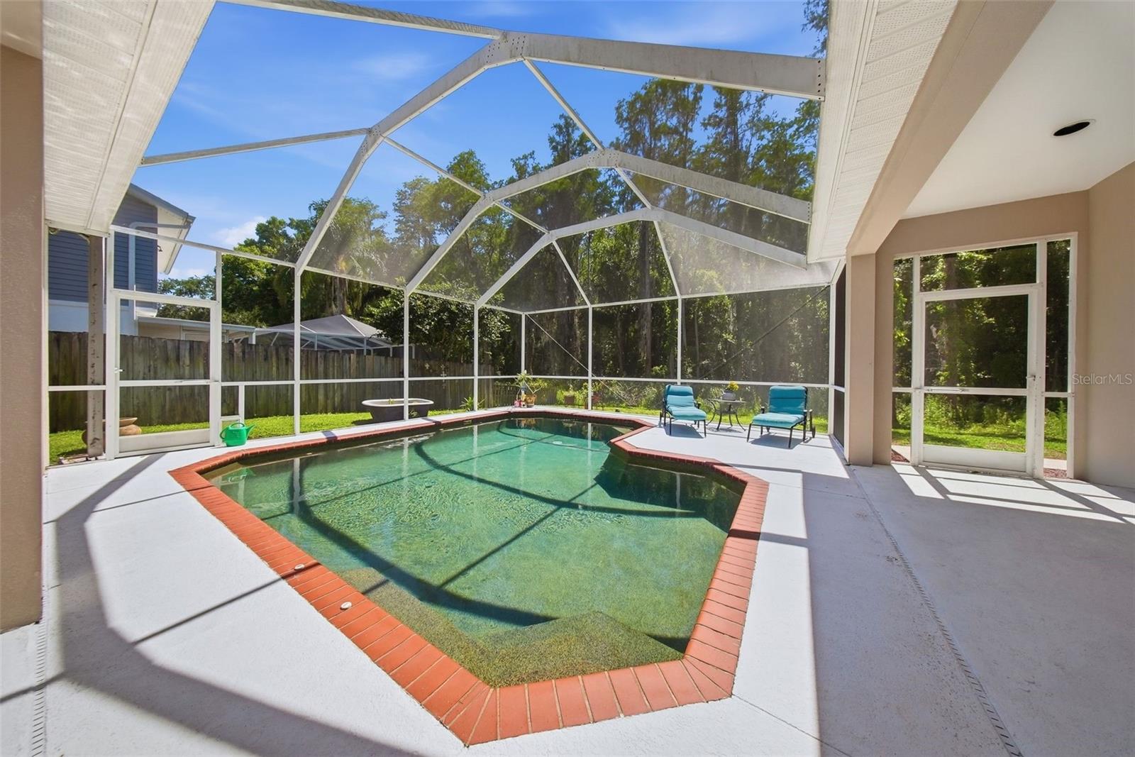 Beautiful salt water pool with a brown pebble tech.
