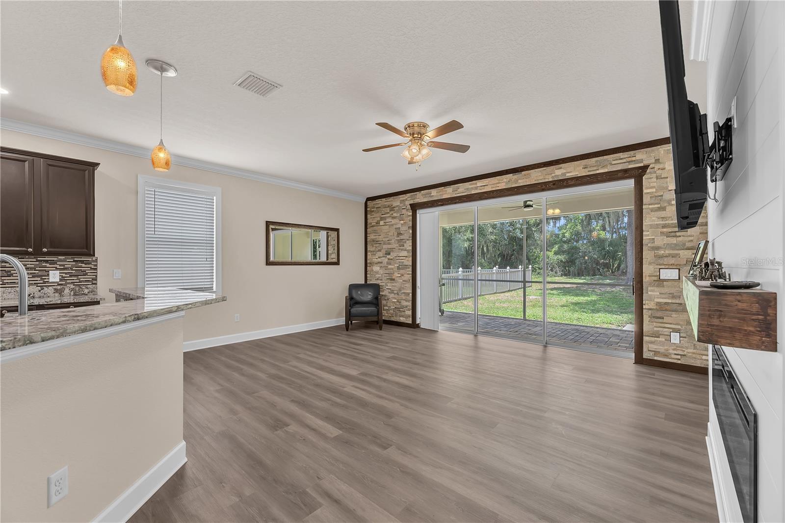 The spacious family room exudes warmth and newly installed luxury vinyl plank flooring enhances the space with a fresh, modern look.