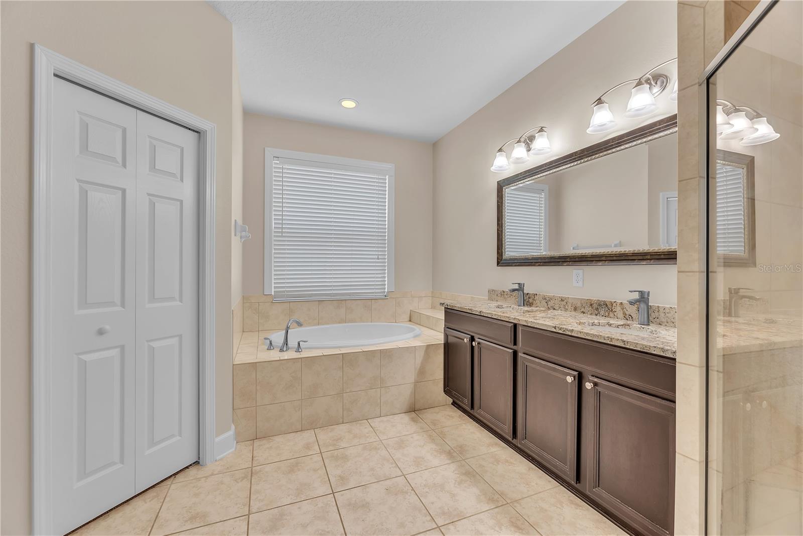 The primary bathroom has dual sinks, a relaxing soaking tub, and separate shower and W/C.