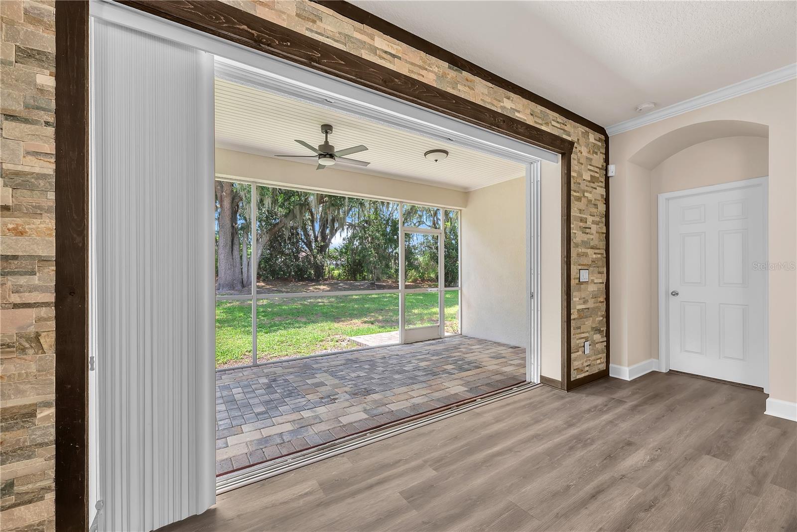 The oversized accordion sliding doors fold back to reveal a spacious covered lanai, extending the family room into an inviting outdoor retreat.