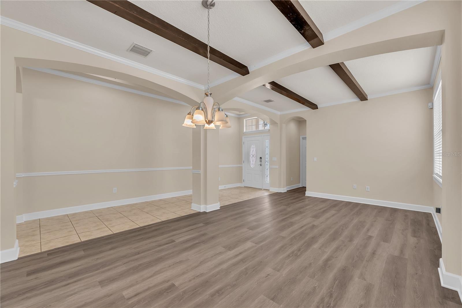 From the moment you enter, you’ll notice the upscale architectural details including tray ceilings, decorative accent beams, crown molding, and luxury vinyl plank flooring throughout the main living areas.