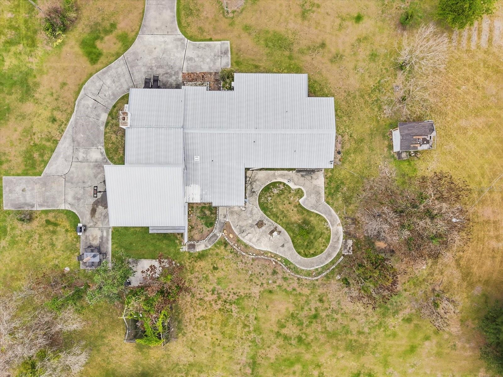 Drone view. Metal roof, large driveway, room to roam