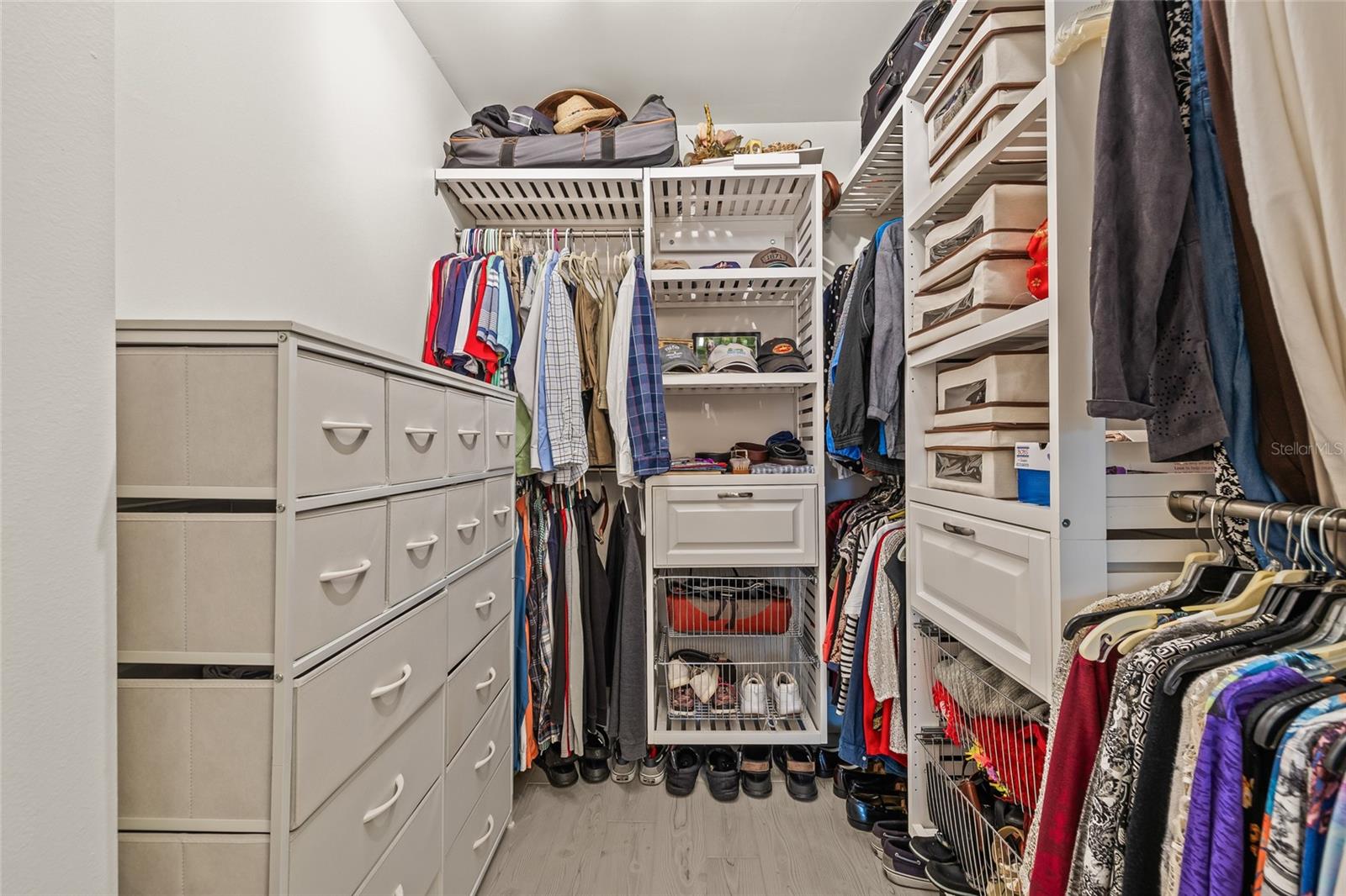 Updated primary walk in closet with shelving system.
