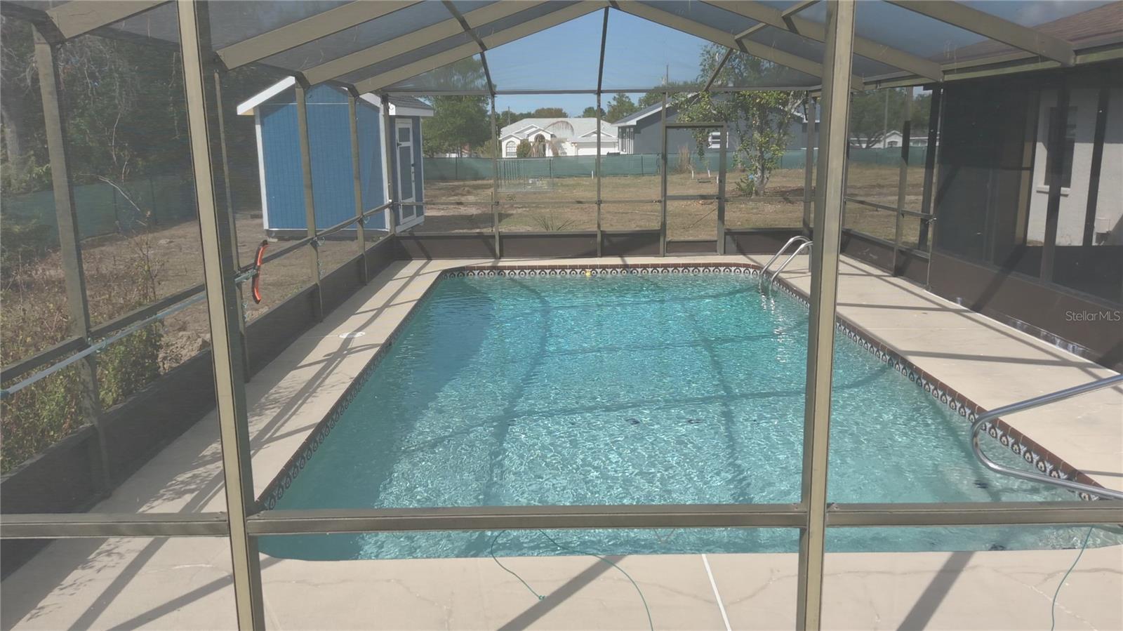 VIEW FROM YARD OF SCREENED LANAI/SALTWATER POOL