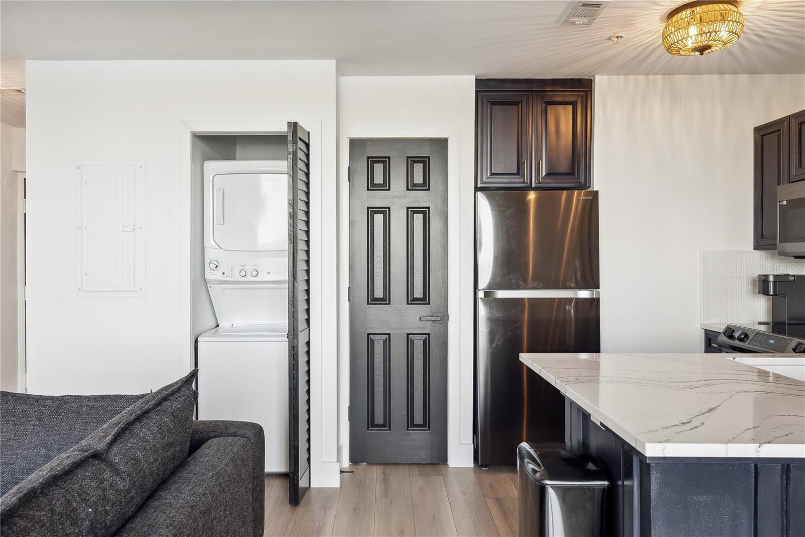 View of kitchen and closet with stack washer/dryer unit