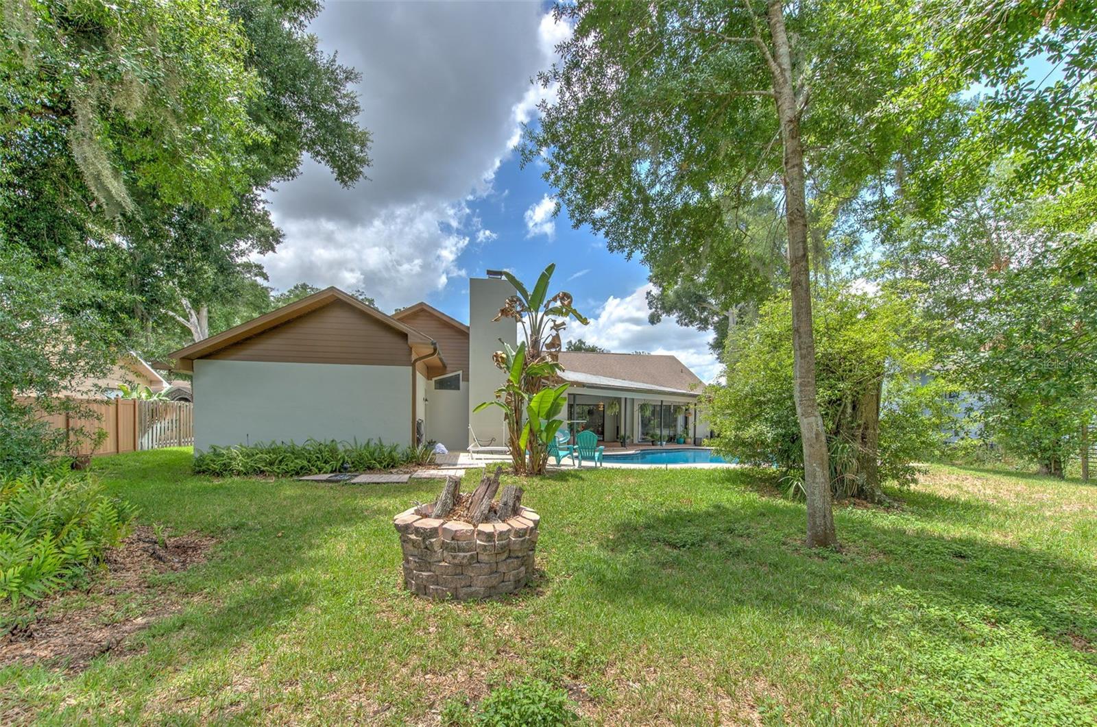 Large yard beyond the pool wtih Firepit