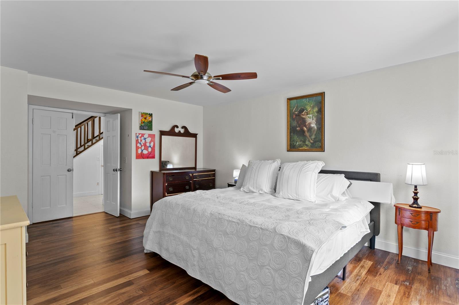 Primary suite features paneled double doors and ceiling fan