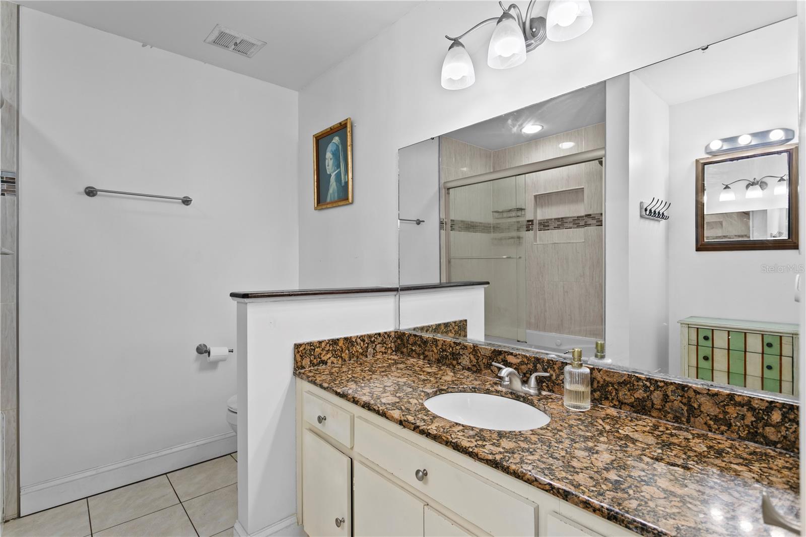 Primary bath with ceramic tile flooring and granite counter top