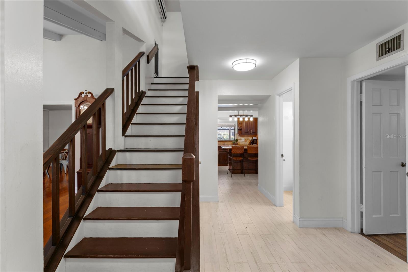 Foyer looking towards the primary suite, hall 1/2 bath and kitchen