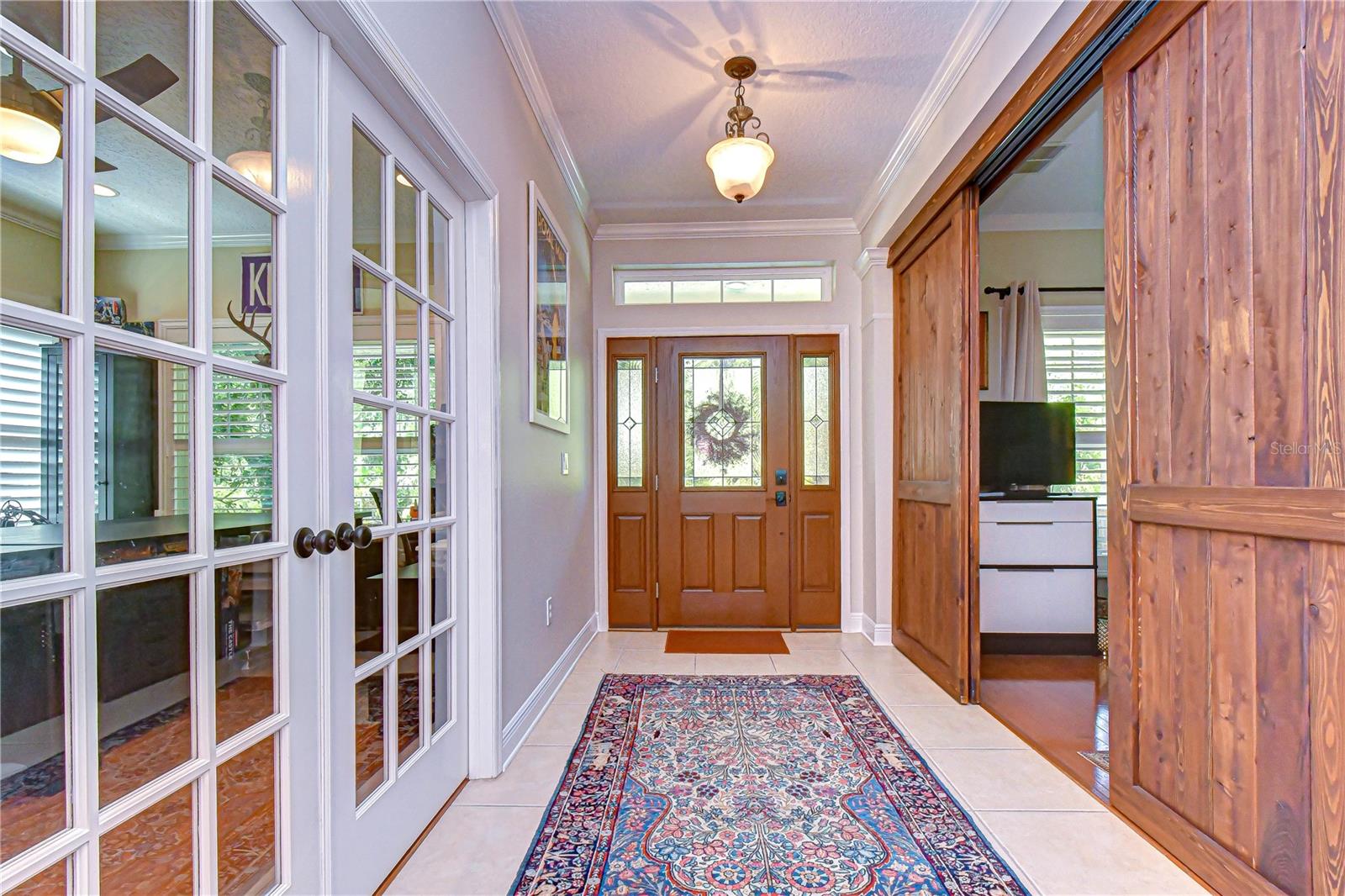 Bright and inviting entrance highlighting timeless craftsmanship and beautiful crown molding.