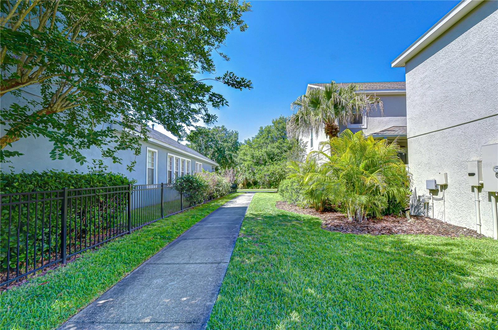 Beautifully landscaped brick and concrete pathways framing the pristine community grounds and neighborhood exterior.