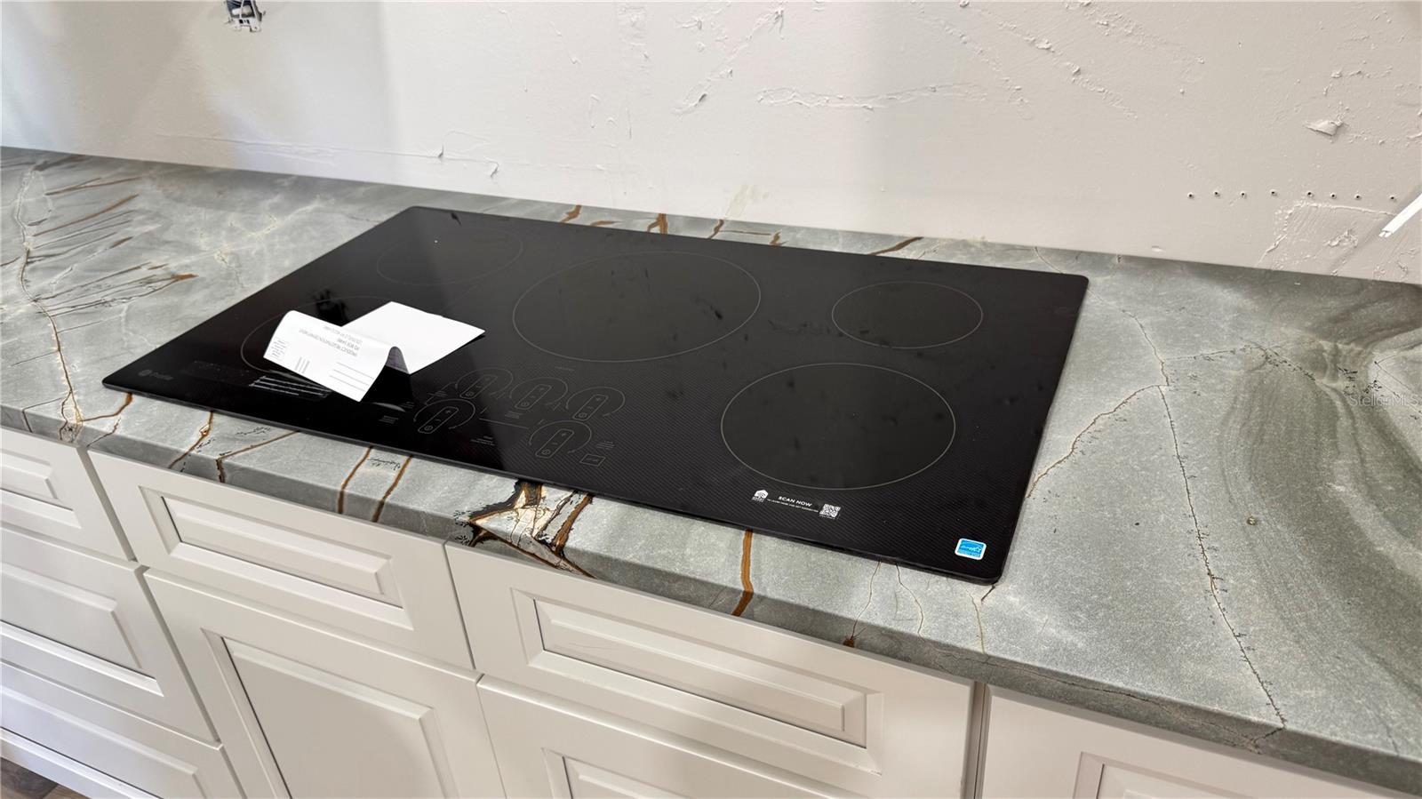 GE induction stovetop embedded in quarzite