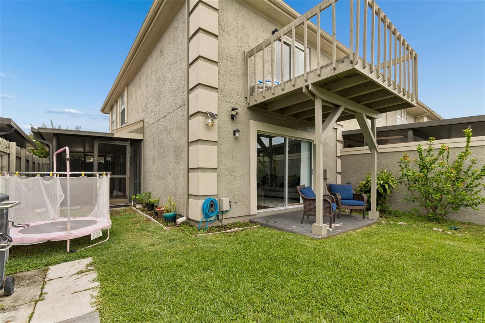 Private backyard featuring both a covered patio and upper-level balcony