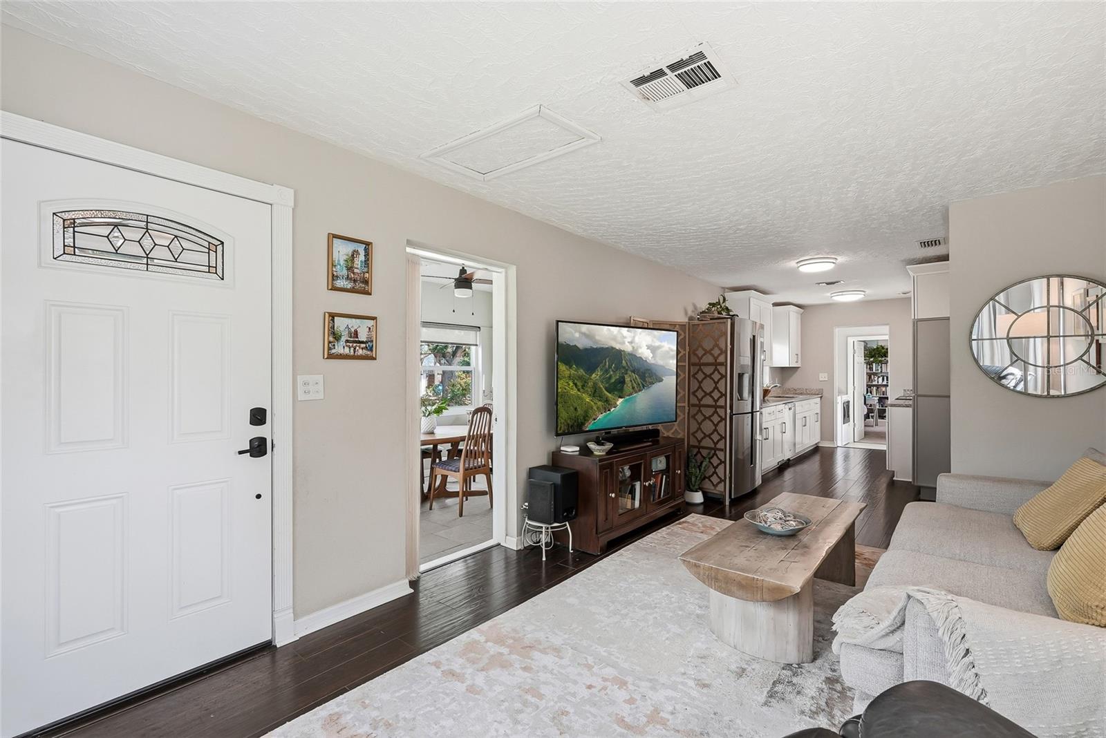 Living room with door to enclosed bonus room.