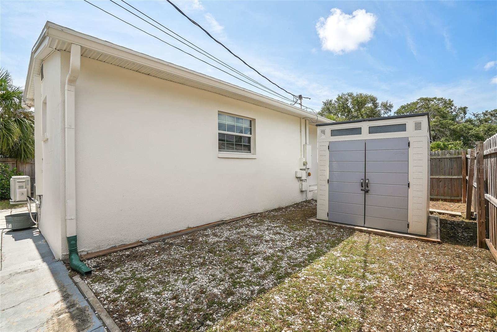 Side yard enclosed within the fenced area for workshop space or protected area for gardening.