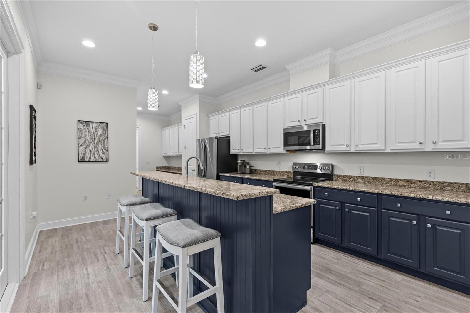 A Chef's dream kitchen with two-toned wood cabinets, prep island and breakfast bar for entertaining guests.
