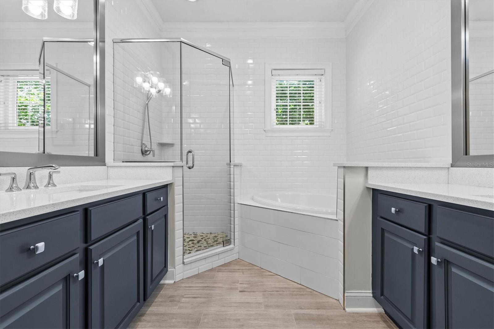 En-suite Primary bath has upgraded quartz counters glass enclosed shower and large soaking tub.