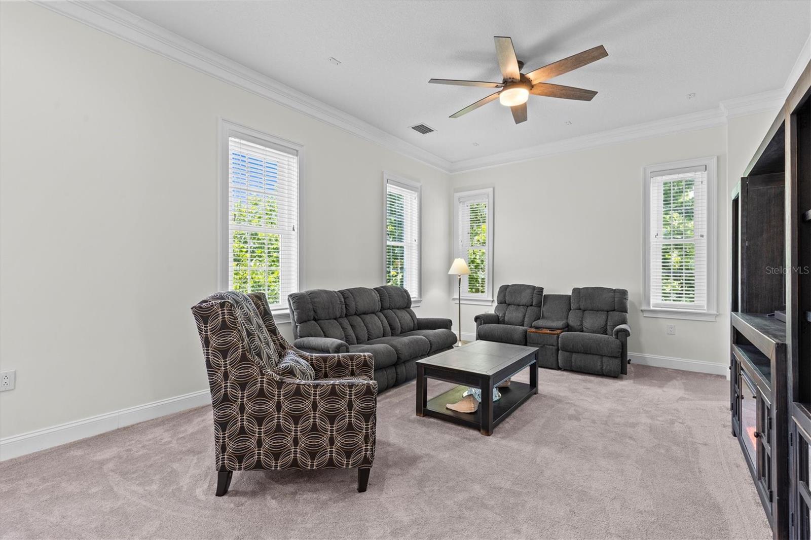Deep crown molding adds elegance and windows flood the space with natural light.