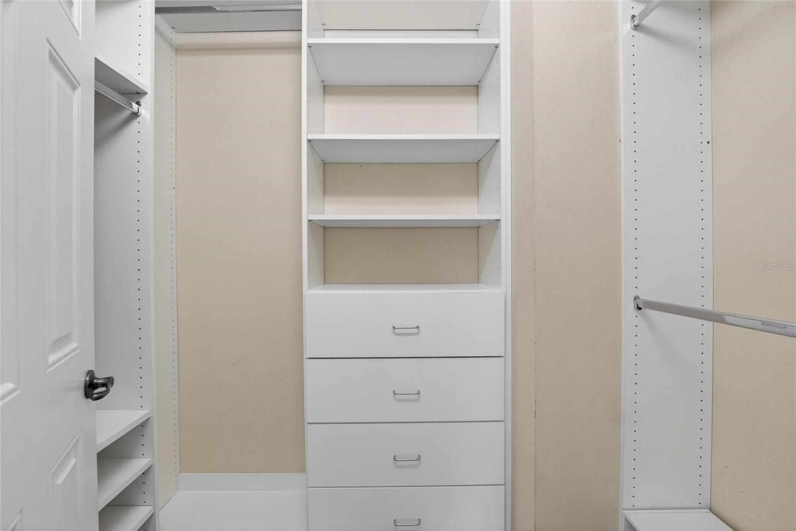 Primary bedroom closet with built ins.