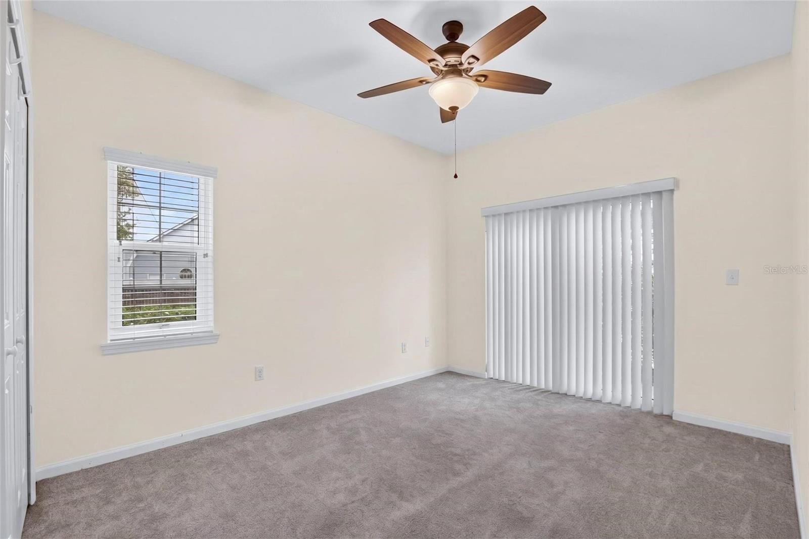 Downstairs bedroom 1 with sliding glass door to patio.