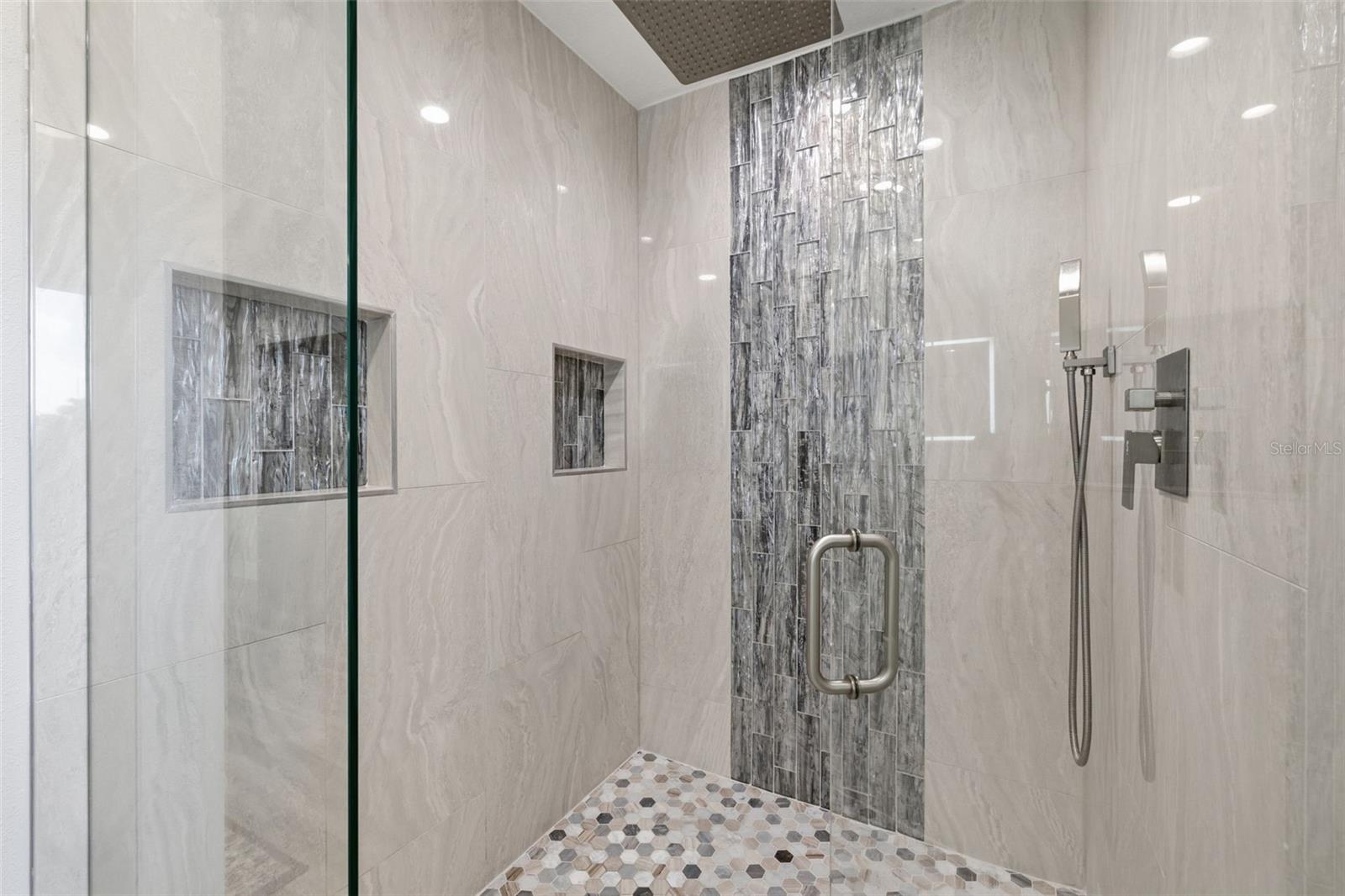 Primary En Suite Walk in Shower! Marble Floor, Travertine Walls! Integrated Rain Shower head! Frameless Glass Enclosure has been treated with anti spotting glass.