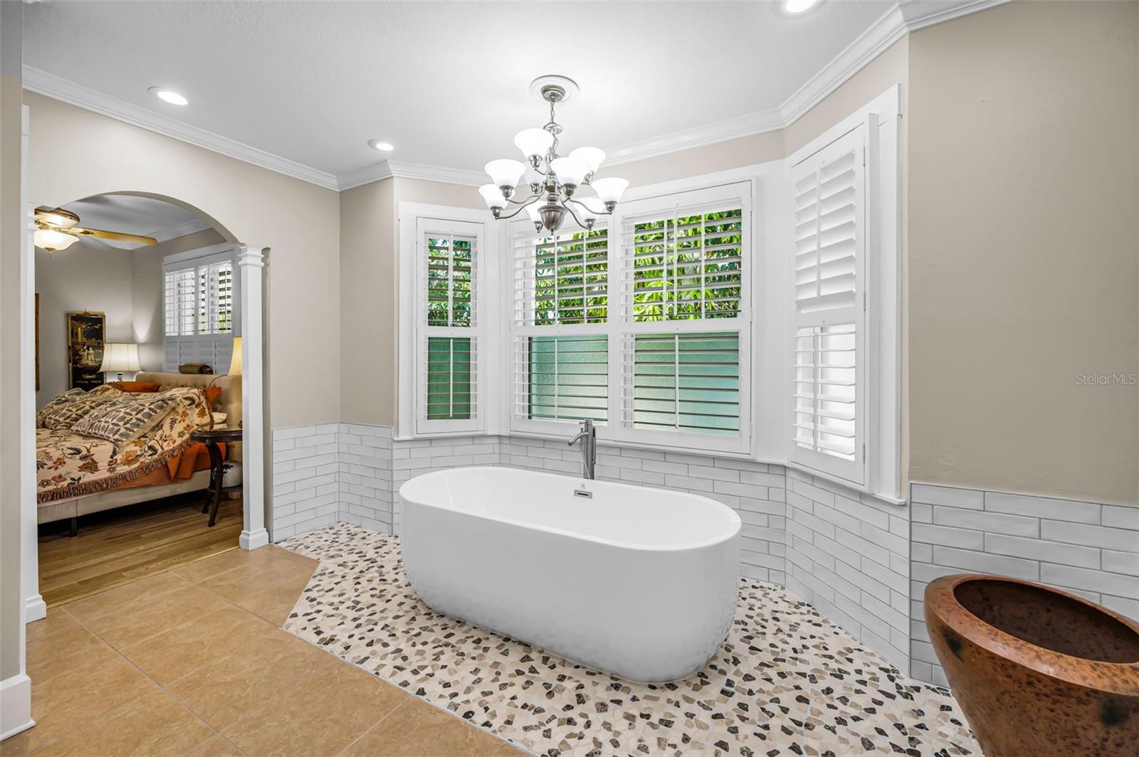 Stand-alone-tub, surrounded by bay windows.