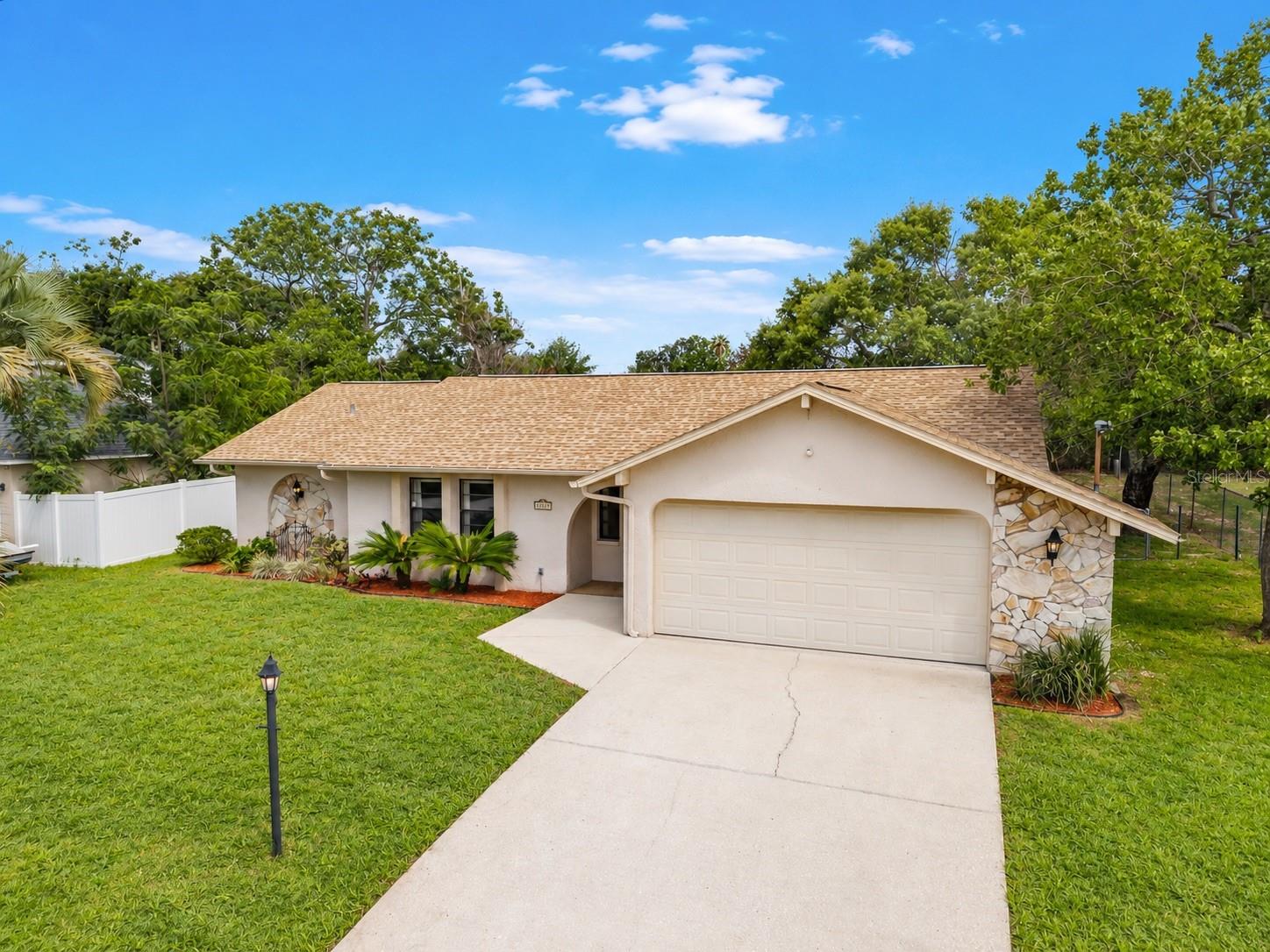 stone accents, fenced yard & arched entryway